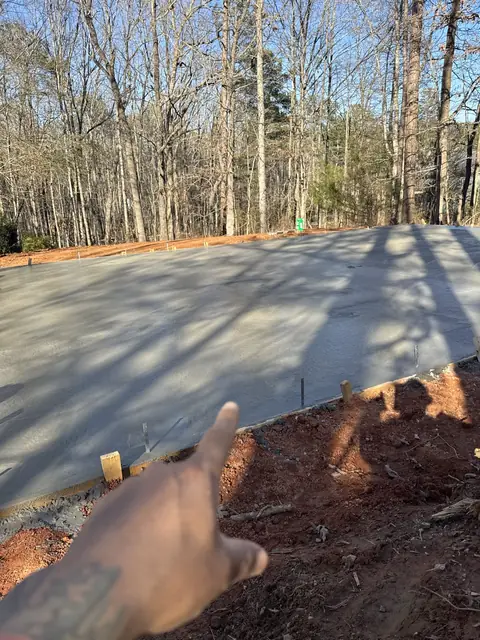 New concrete driveway poured along a wooded lot