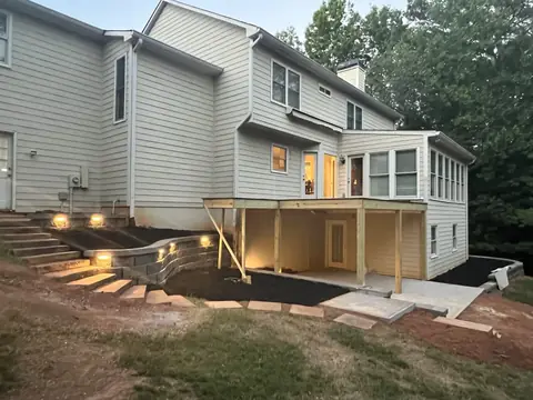 Finished backyard: new deck with lit steps, block retaining wall and concrete patio