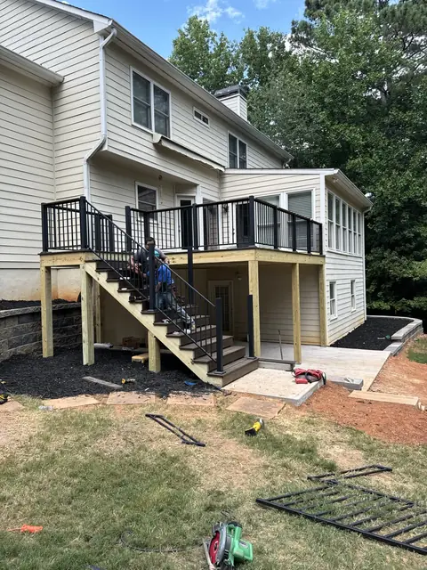 New deck and stairs above a block retaining wall and patio